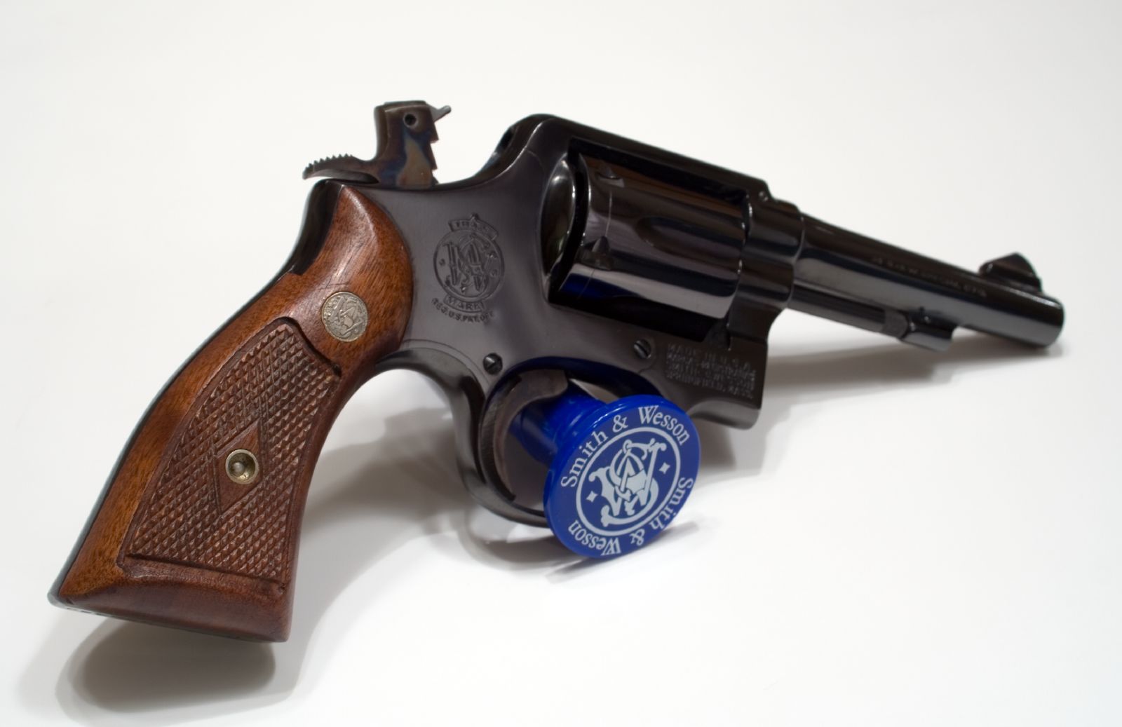 A blued Smith & Wesson K-frame revolver with wood grips and factory medallion